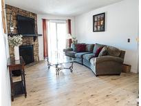 Inviting living room features a stone fireplace, wood floors, and sliding glass doors to the outside at 14413 E Jewell Ave # 201, Aurora, CO 80012