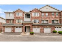 Charming townhouse featuring red brick, individual garages, and well-maintained landscaping at 8944 Fox Dr # 203, Thornton, CO 80260