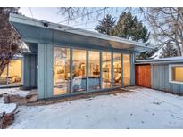 Mid-century modern home with a large window wall and snow-covered yard at 2590 S Meade St, Denver, CO 80219