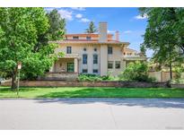 Elegant home with a red tile roof, classic architecture, and a well-maintained front lawn and brick retaining wall at 199 Lafayette St, Denver, CO 80218