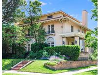 Stunning two-story home featuring a terracotta roof, manicured lawn, and beautiful landscaping at 199 Lafayette St, Denver, CO 80218