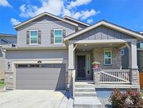Charming two-story home with gray siding, stone accents, and a covered front porch at 656 N Bersshine St, Watkins, CO 80137