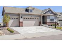 Charming home showcasing a three-car garage, brick accents, and well-manicured landscaping, creating a welcoming curb appeal at 15842 Willow St, Thornton, CO 80602