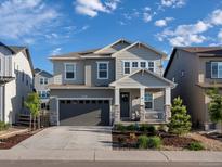 Charming two-story home with gray siding, covered porch, landscaped yard, and attached two-car garage at 8354 Big Thompson St, Littleton, CO 80125