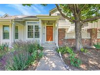 Inviting home entrance with a wooden door and beautiful landscaping at 2972 W Long Dr # C, Littleton, CO 80120