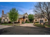 Stunning stone home with a circular driveway, mature landscaping, and welcoming curb appeal at 4 Redhawk Run, Englewood, CO 80113