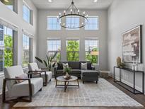 Bright living room featuring soaring ceilings and large windows at 5399 Valentia St, Denver, CO 80238