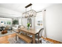 Bright dining room features hardwood floors, modern lighting, and a rustic wood table and bench seating at 1757 S Elm St, Denver, CO 80222