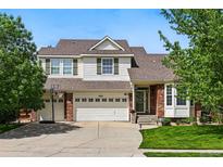 Charming two-story home with a well-manicured lawn, three-car garage, and brick and siding facade at 4915 Sage Brush Dr, Broomfield, CO 80023