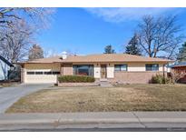 Charming single-story home featuring a well-manicured lawn and attached garage at 3615 S Hibiscus Way, Denver, CO 80237