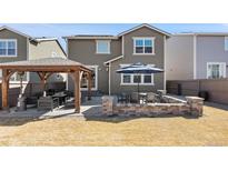 Inviting backyard featuring a pergola, outdoor dining area, and a well-maintained lawn at 10597 Casper St, Parker, CO 80134