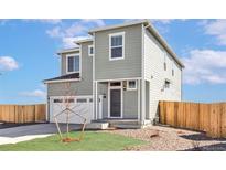 Inviting two-story home featuring a gray exterior, well-kept lawn, and attached two-car garage at 17850 E 94Th Ave, Commerce City, CO 80022