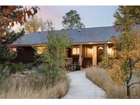 Charming home featuring a covered front porch, landscaped yard, and inviting walkway at 1800 S Niagara Way, Denver, CO 80224