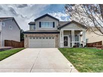 Charming two-story home featuring a brick garage and a welcoming front porch with stylish columns at 10554 Tracewood Cir, Highlands Ranch, CO 80130