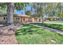 Charming ranch-style home with a well-manicured lawn and mature trees providing shade at 4960 S Fox St, Englewood, CO 80110