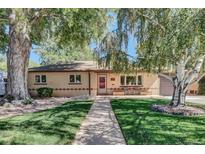 Charming single-story home featuring a well-manicured lawn, mature trees, and inviting front porch at 4960 S Fox St, Englewood, CO 80110