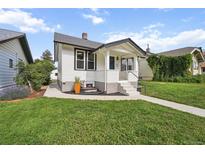 Charming home with a well-manicured lawn and inviting front porch at 3226 Grant St, Englewood, CO 80113