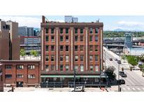 Brick apartment building with street view and mountain backdrop showcasing city living at 2261 Blake St # 2G, Denver, CO 80205