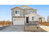 Charming two-story home with gray siding, stone accents, and a two-car garage at 1402 Rock Cliff Ave, Erie, CO 80516