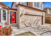 Two-story home features a red front door and attached two-car garage at 9662 Newcastle Dr, Highlands Ranch, CO 80130