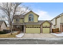 Two-story house with a green facade, two-car garage, and well-maintained lawn at 10463 Adams St, Northglenn, CO 80233