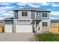 Two-story home showcasing a two-car garage, stone accents, and a manicured lawn beneath a bright sky at 3234 Belleville Ridge Rd, Elizabeth, CO 80107