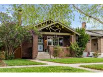 Charming brick bungalow featuring well-maintained lawn and beautiful landscaping at 2641 N Clayton St, Denver, CO 80205