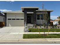 Attractive single-story home boasting a stone facade, a two-car garage, and well-maintained landscaping at 1111 Joseph Pl, Erie, CO 80026