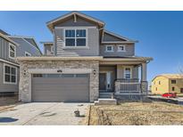 Charming two-story home featuring stone accents, neutral siding, a two-car garage, and well-manicured landscaping at 739 N Deer Park St, Watkins, CO 80137