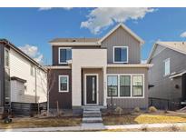 Inviting two-story home with modern design, dark trim windows, and a well-manicured lawn at 6209 Stable View St, Castle Pines, CO 80108