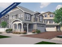 Charming gray home with covered porch, manicured landscaping and a two-car garage at 1169 Highview Dr, Erie, CO 80516