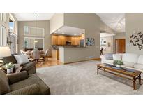 Open-concept living room featuring hardwood floors, recessed lighting, and a breakfast bar overlooking the kitchen at 735 Orchard Ct, Louisville, CO 80027