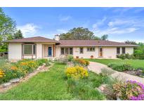 Charming ranch style home with lovely flower beds and a welcoming walkway to the front door at 2020 Routt St, Lakewood, CO 80215