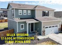 Charming two-story home with a two car garage, inviting front porch and stone accents under a blue sky at 17947 E 95Th Ave, Commerce City, CO 80022