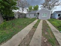 Charming single-story home with grey siding, a driveway, and a partially landscaped front yard at 1717 Oswego St, Aurora, CO 80010