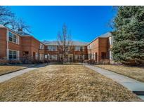 Brick multifamily building with a well-maintained lawn and charming architectural details at 2823 Jasmine St, Denver, CO 80207