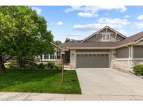 Charming home with a well-manicured front lawn, mature tree, and a two-car garage at 8216 S Tempe Ct, Aurora, CO 80016