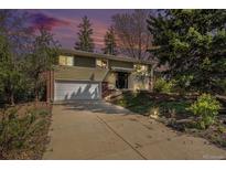 Charming two-story home with mature trees, a paved driveway, and an attached two-car garage at 1244 S Wright St, Lakewood, CO 80228