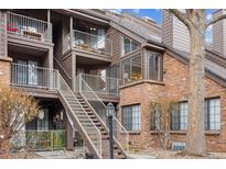 Multi-level condo building with brick and siding exterior, featuring balconies and well-maintained landscaping at 836 S Vance St # E, Lakewood, CO 80226