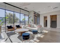 Bright living room with large windows, modern furniture, and contemporary lighting fixture at 1735 Central St # 208, Denver, CO 80211