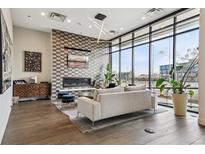 Inviting living room with a fireplace, large windows and hardwood floors, perfect for relaxation and entertaining at 1735 Central St # 208, Denver, CO 80211