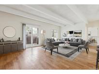 Bright and airy living room featuring hardwood floors, modern decor, and sliding glass doors to a private balcony at 9700 E Iliff Ave # G70, Denver, CO 80231