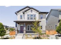 Charming two-story home featuring a covered porch and a beautifully designed exterior at 6037 N Netherland Ct, Aurora, CO 80019
