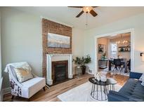 Inviting living room with exposed brick fireplace, modern decor and natural light, creating a cozy and stylish atmosphere at 2564 N Emerson St, Denver, CO 80205