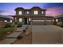 Inviting two-story home featuring a stone facade, three-car garage, and manicured landscaping at 76 N Ider St, Aurora, CO 80018