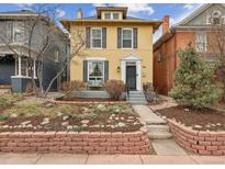 Charming two-story yellow home with a brick garden and a welcoming front entrance at 263 N Logan St, Denver, CO 80203