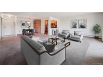 Inviting living room with modern decor and an open floor plan leading to the dining area and kitchen at 13618 E Bethany Pl # 306, Aurora, CO 80014