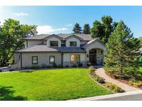 Charming two-story home featuring manicured front lawn and inviting brick walkway at 4181 S Ivy Ln, Cherry Hills Village, CO 80111