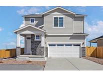 Charming two-story home featuring a two-car garage and stone accents at 9454 Yampa St, Commerce City, CO 80022