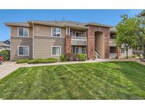 Inviting multi-story condo building with well-maintained lawn, complemented by tasteful landscaping and brick architectural accents at 8481 W Union Ave # 2-103, Littleton, CO 80123